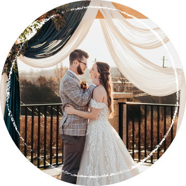 Couple embraces under a fabric draped wedding arbor overlooking the blueberry patch at Berry Barn Farms in Jefferson City, MO.