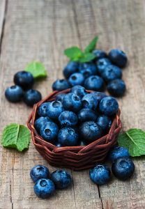 bowl of blueberries on a wooden table